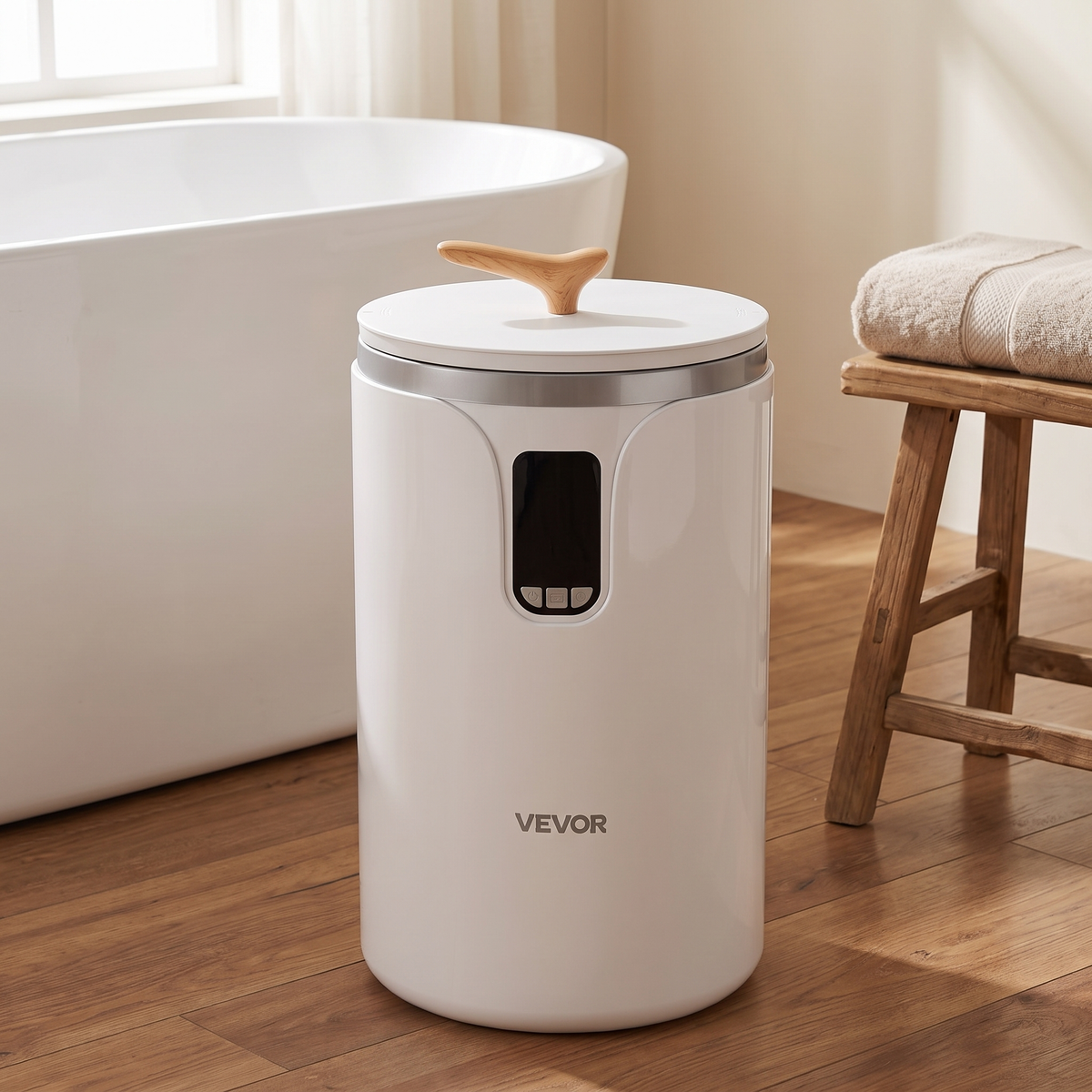 White cylinder towel warmer bucket with silver rim, front display and round lid beside a bathtub